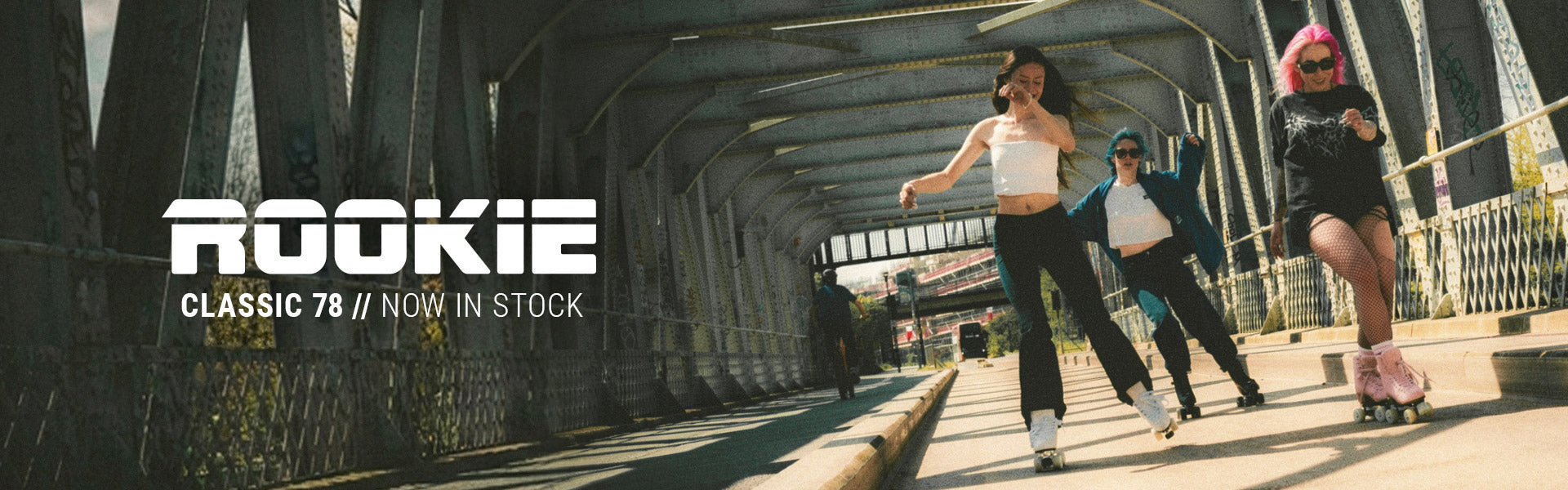Three people roller skate under a metal bridge, exuding joy and energy. Bold text reads "Rookie Classic 78 // Now in Stock".