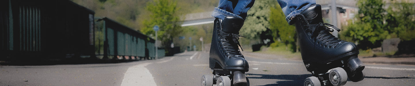 A person rollerskating outside wearing black Rookie Roller skates.